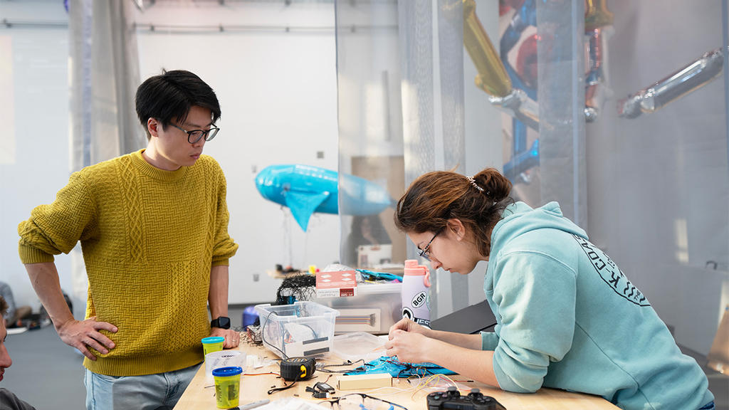George Mason professor supervises student assembling a blimp model