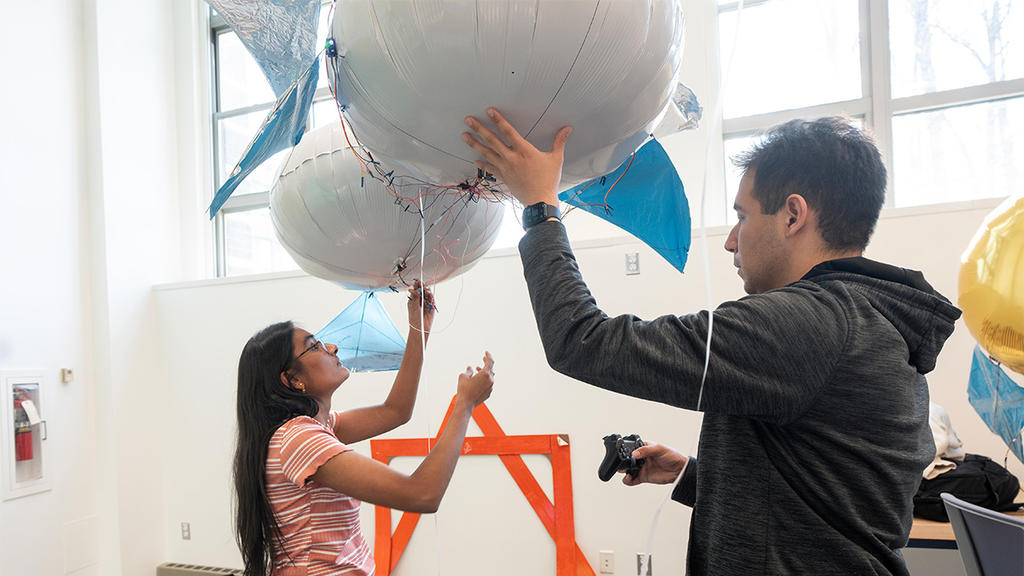 Two George Mason students operate a autonomous blimp
